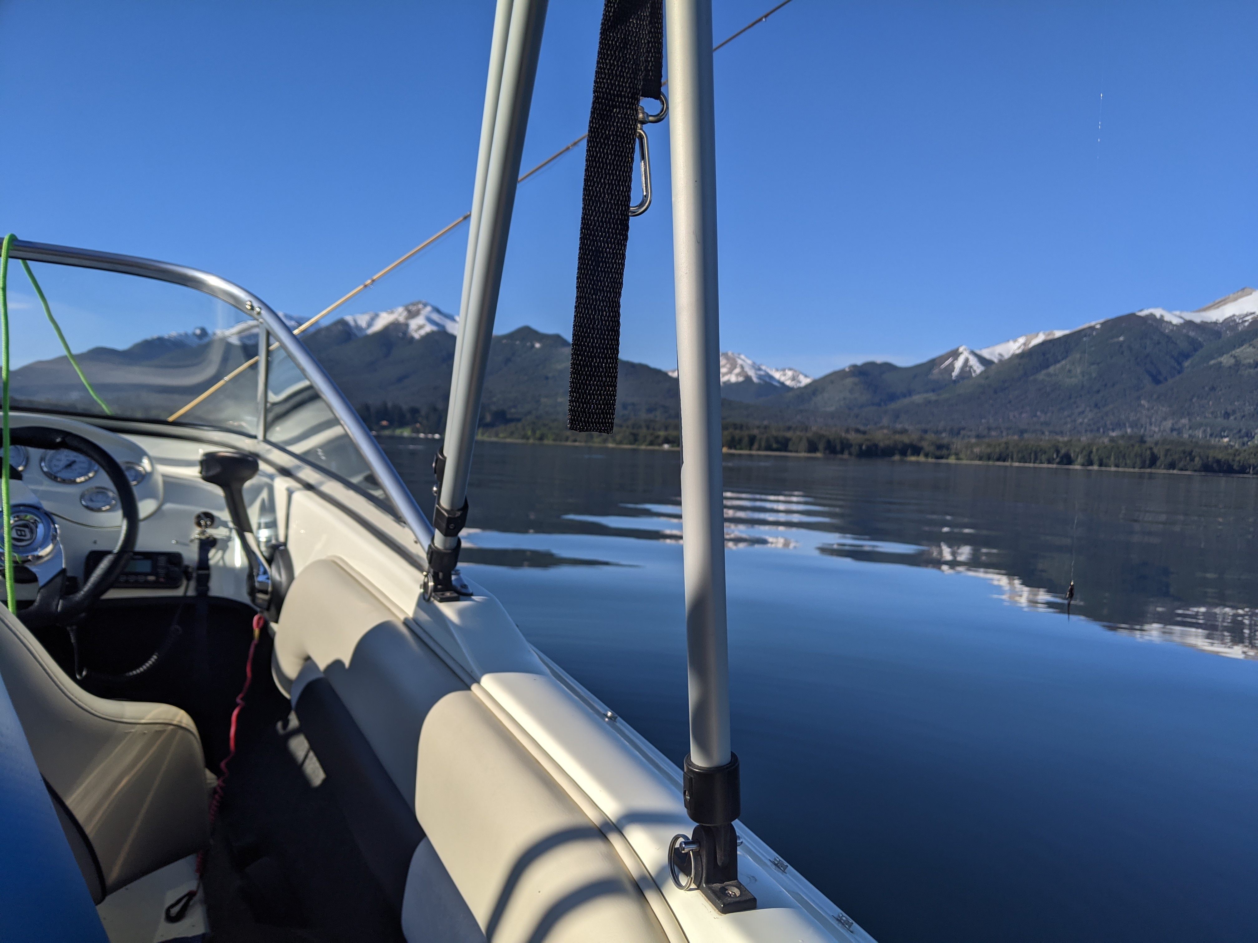Lancha navegando el lago con vista a las montañas nevadas